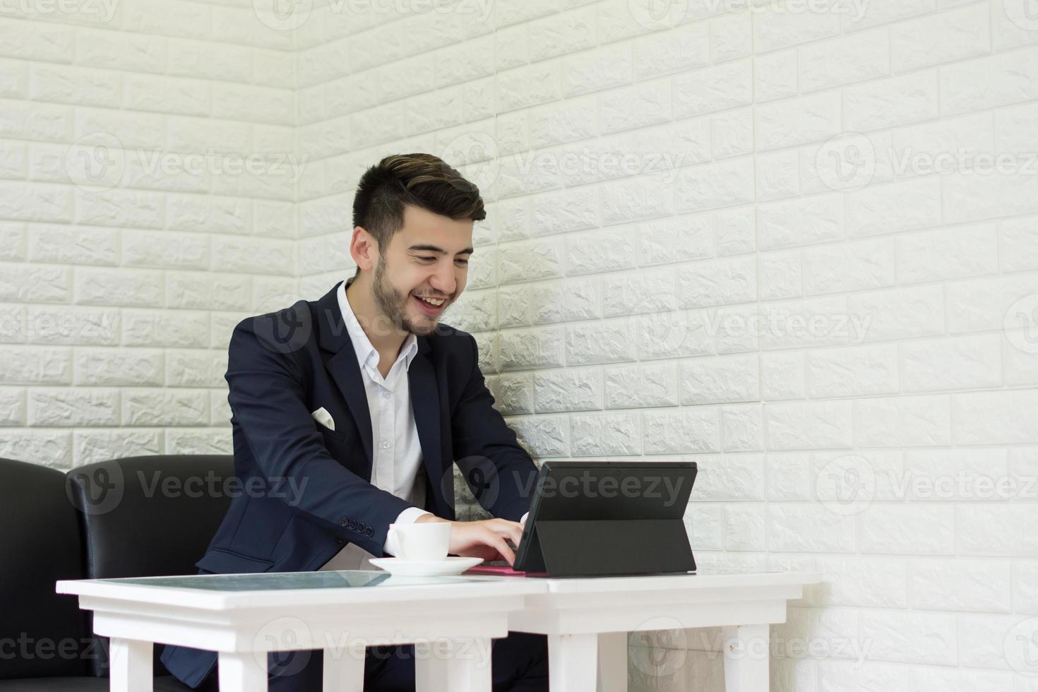 succesvolle jonge zakenman die op laptop op kantoor werkt foto