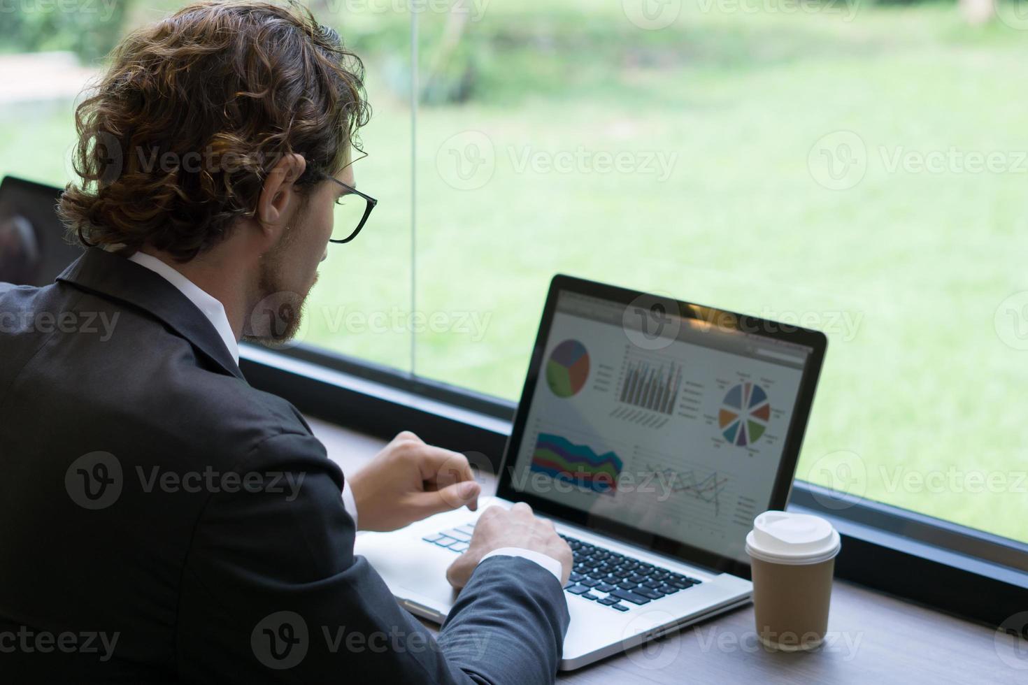 jonge zakenman die op laptop op kantoor werkt foto