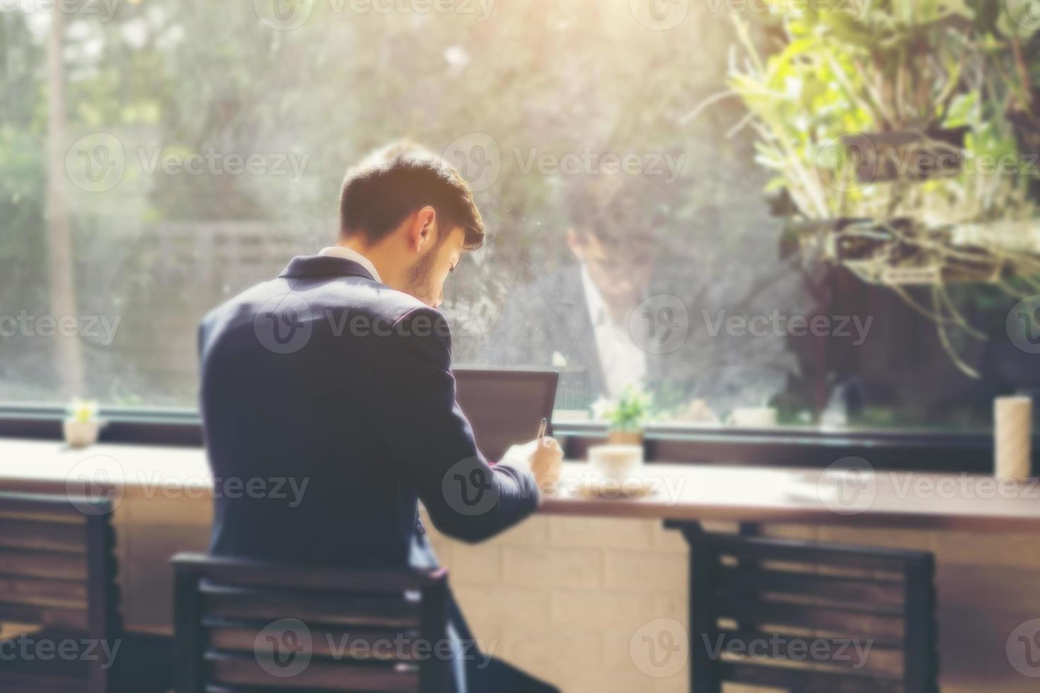 jonge zakenman draagt een pak en laptop gebruikt in een café foto