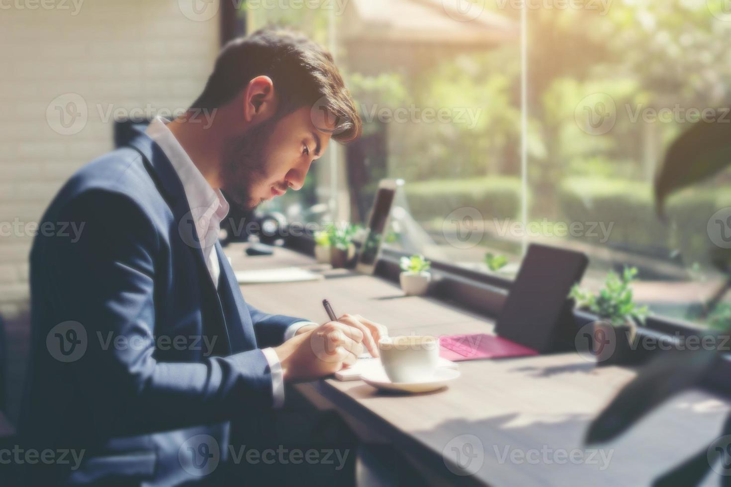 jonge zakenman draagt een pak en laptop gebruikt in een café foto