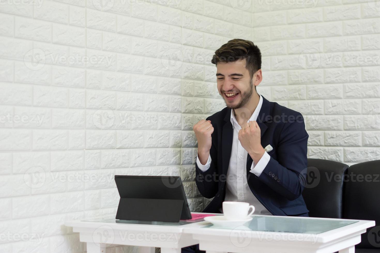 succesvolle jonge zakenman die op laptop op kantoor werkt foto