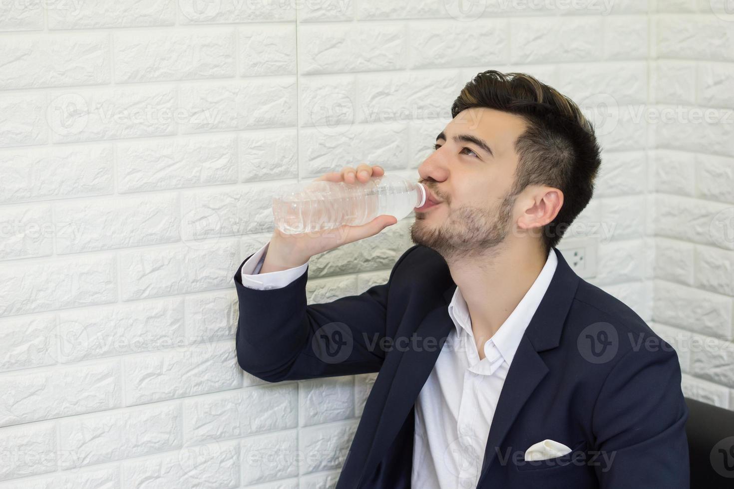 jonge zakenman drinkwater op kantoor foto