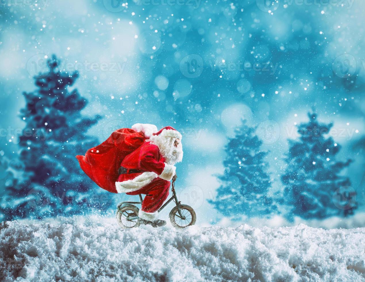 de kerstman claus Aan een weinig fiets Aan een winter landschap onder de sneeuw foto
