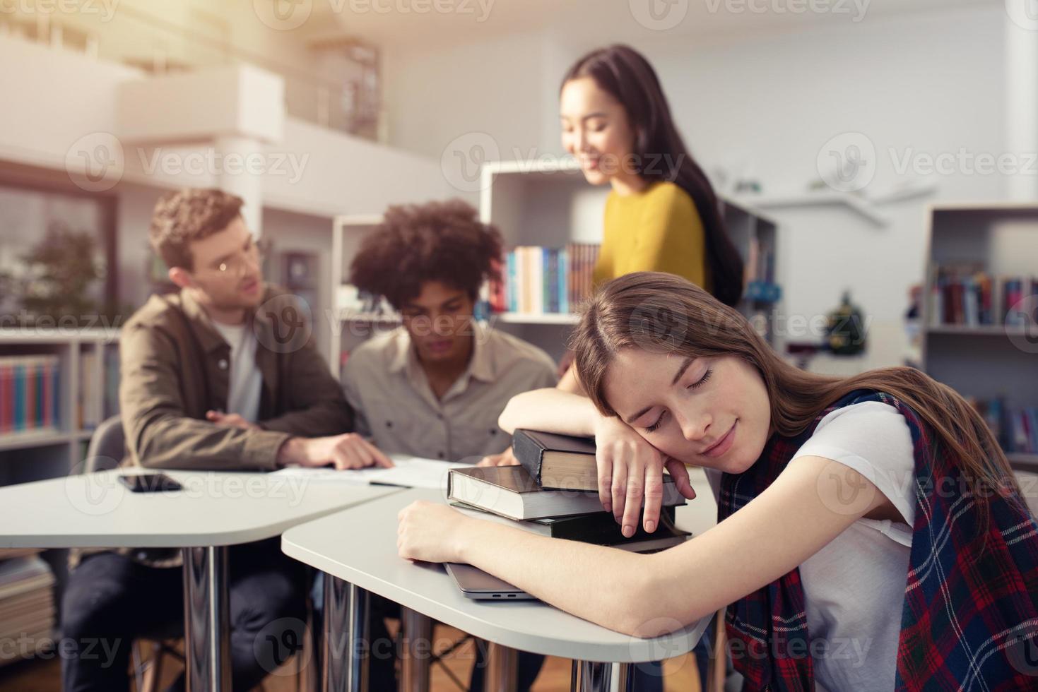 moe meisje slaapt over- boeken gedurende een vergadering met studenten. concept van spanning en na een tijdje foto