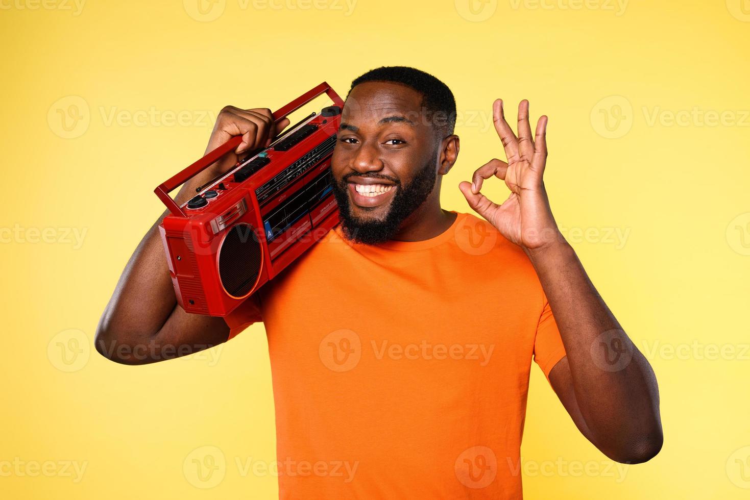 Mens oren de muziek- met een oud stereo en dansen. emotioneel en energiek uitdrukking. geel achtergrond foto