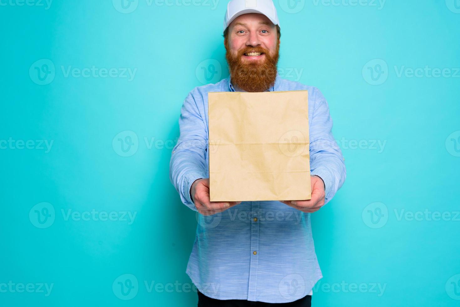 postbode met gelukkig uitdrukking is klaar naar leveren een voedsel pakket foto