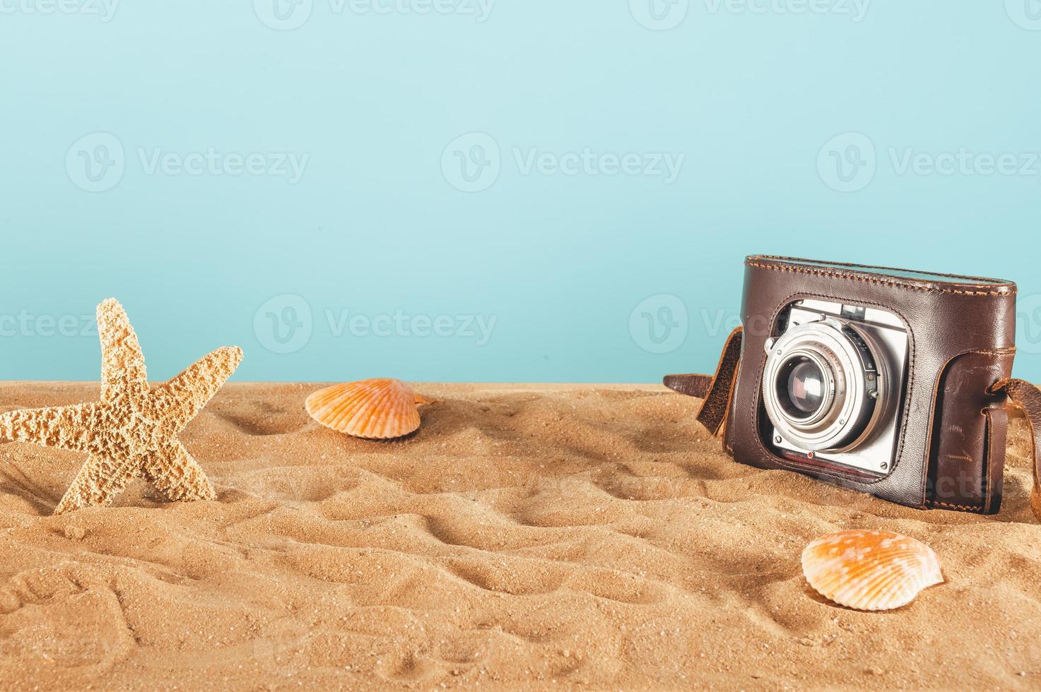 achtergrond van strand met schelpen, zeester en een retro foto camera