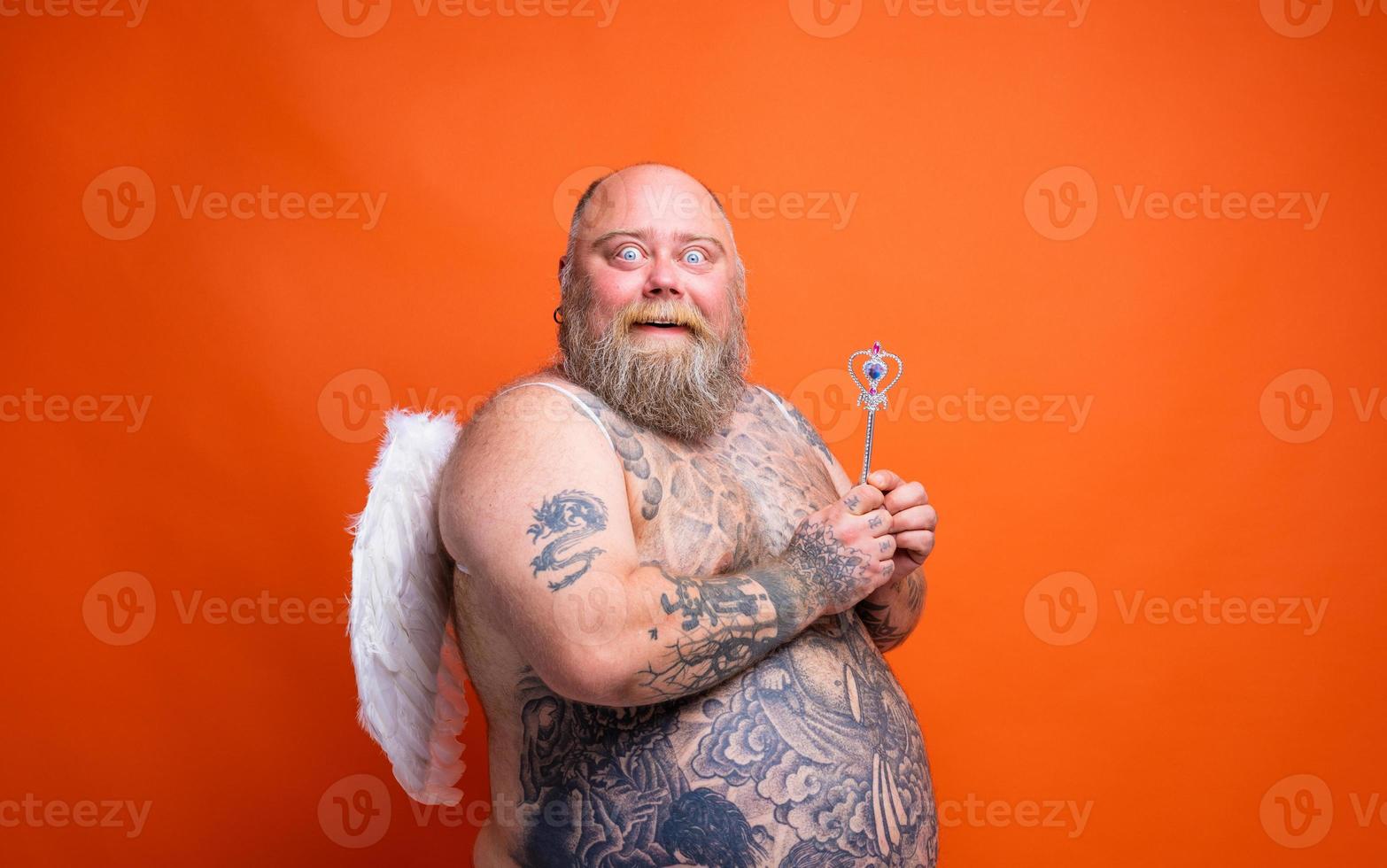 dik versteld staan Mens met baard , tatoeages en Vleugels handelingen Leuk vinden een magie fee foto