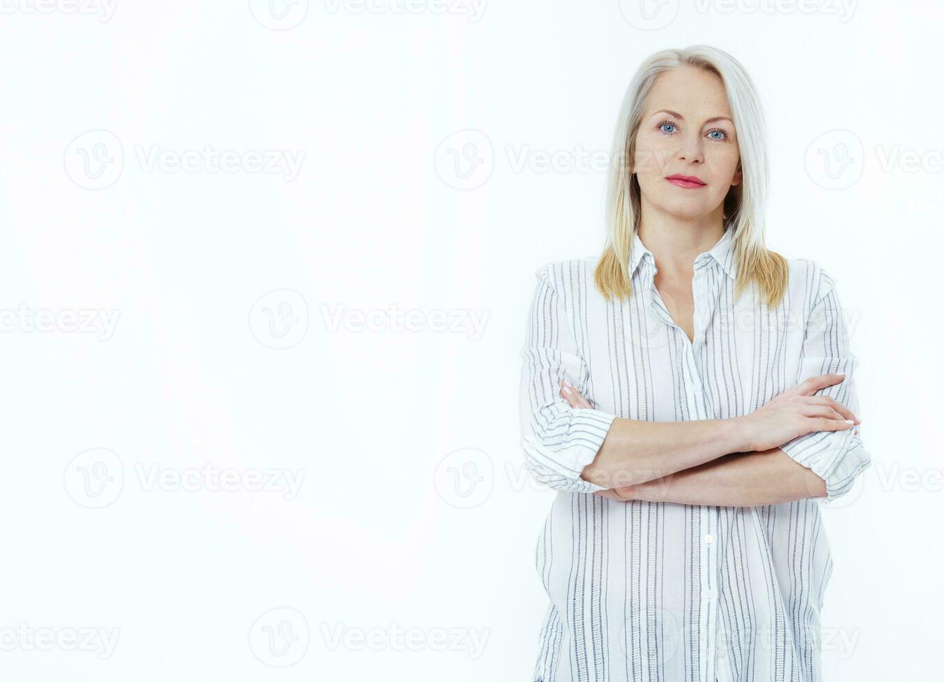 aantrekkelijk midden- oud vrouw met gevouwen armen geïsoleerd Aan wit achtergrond foto