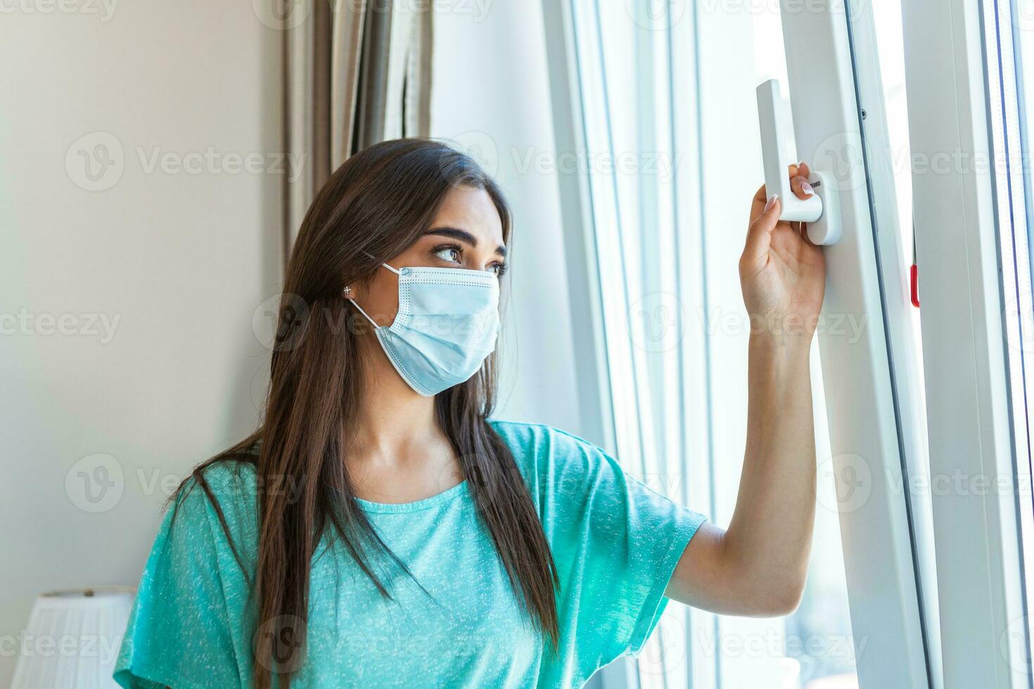 huis quarantaine. Kaukasisch vrouw zittend Bij venster in een medisch masker, op zoek uit, wil naar Gaan uit. bescherming tegen coronavirus infectie, pandemieën, ziekte uitbraken en epidemieën. foto