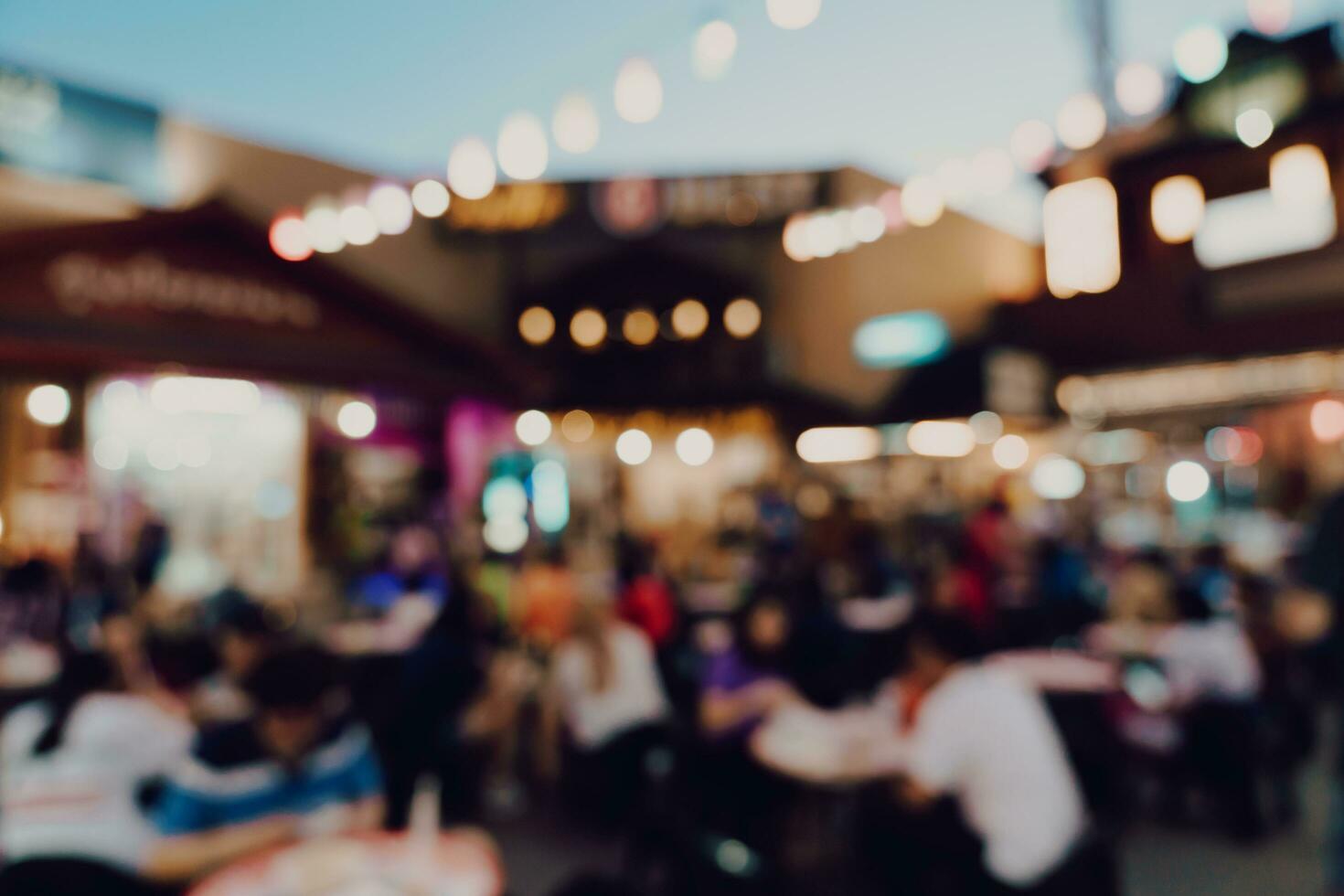 wazig achtergrond Bij nacht markt festival mensen wandelen Aan weg. foto