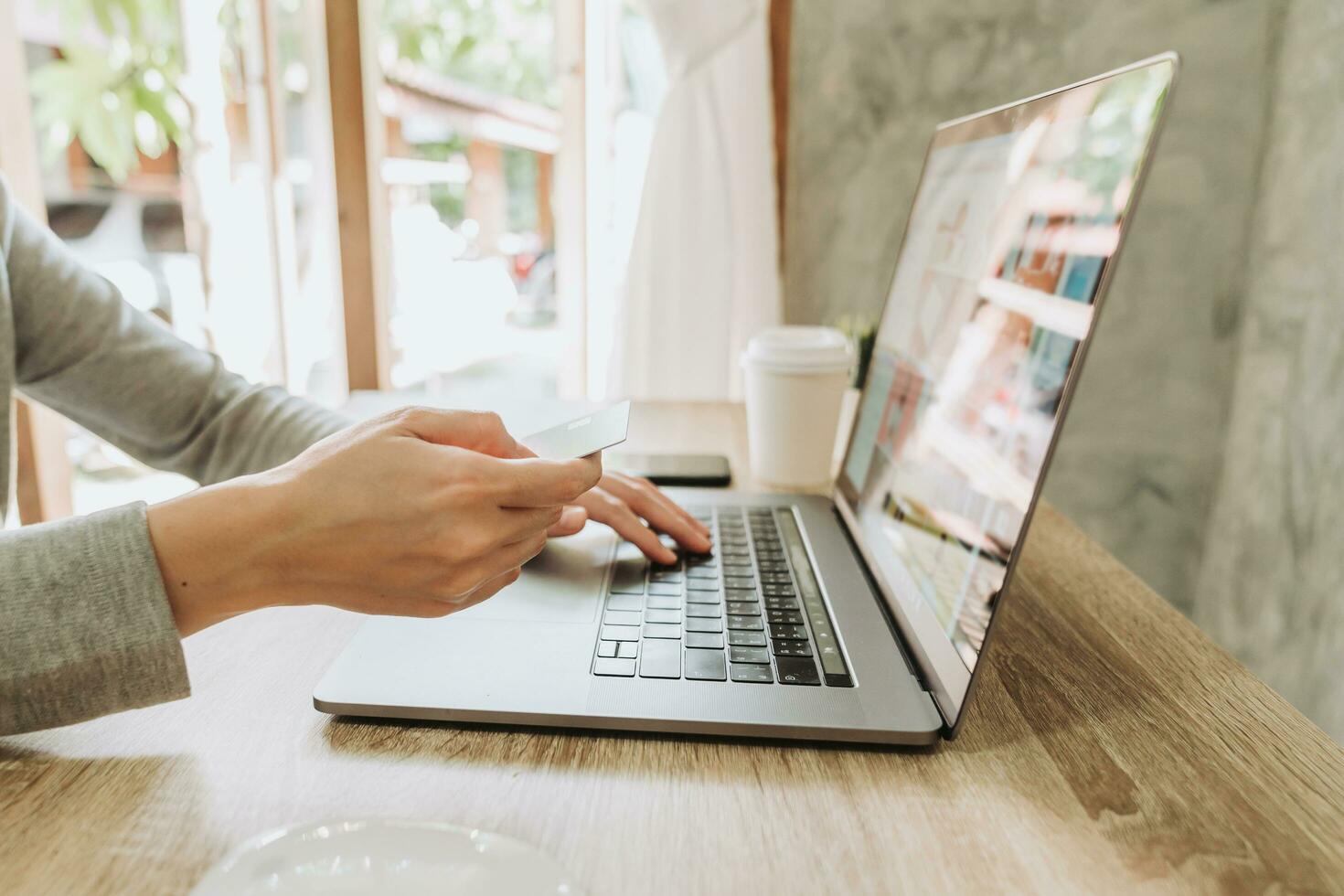 vrouw hand- Holding credit kaart en gebruik makend van laptop voor boodschappen doen online foto