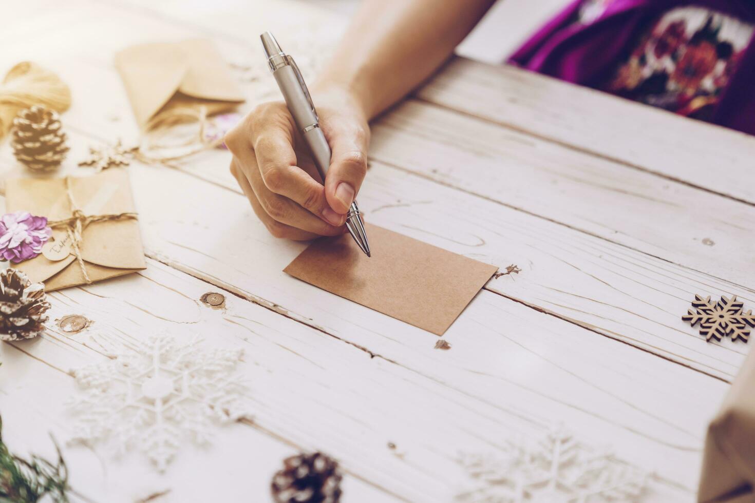 vrouw hand- schrijven mooi Kerstmis kaart Bij tafel foto