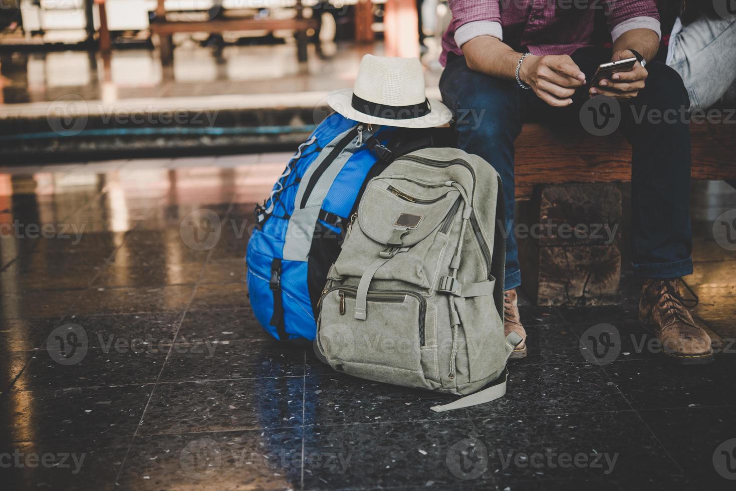 jonge hipster man zittend op een bankje op het treinstation foto