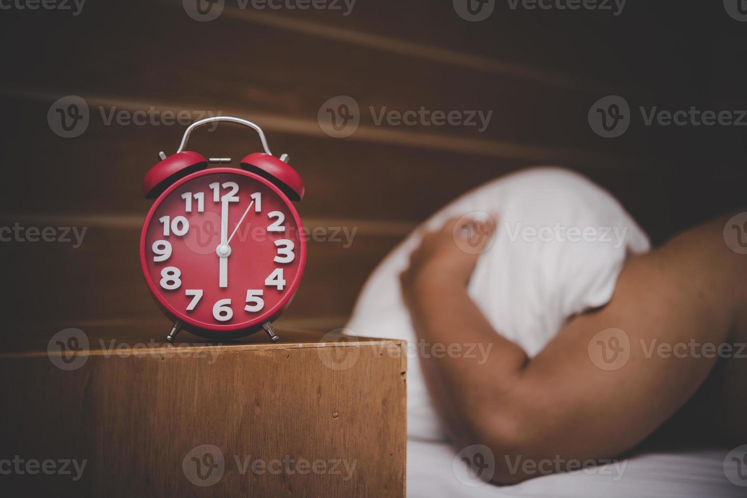 man wordt gewekt door een wekker in zijn slaapkamer foto