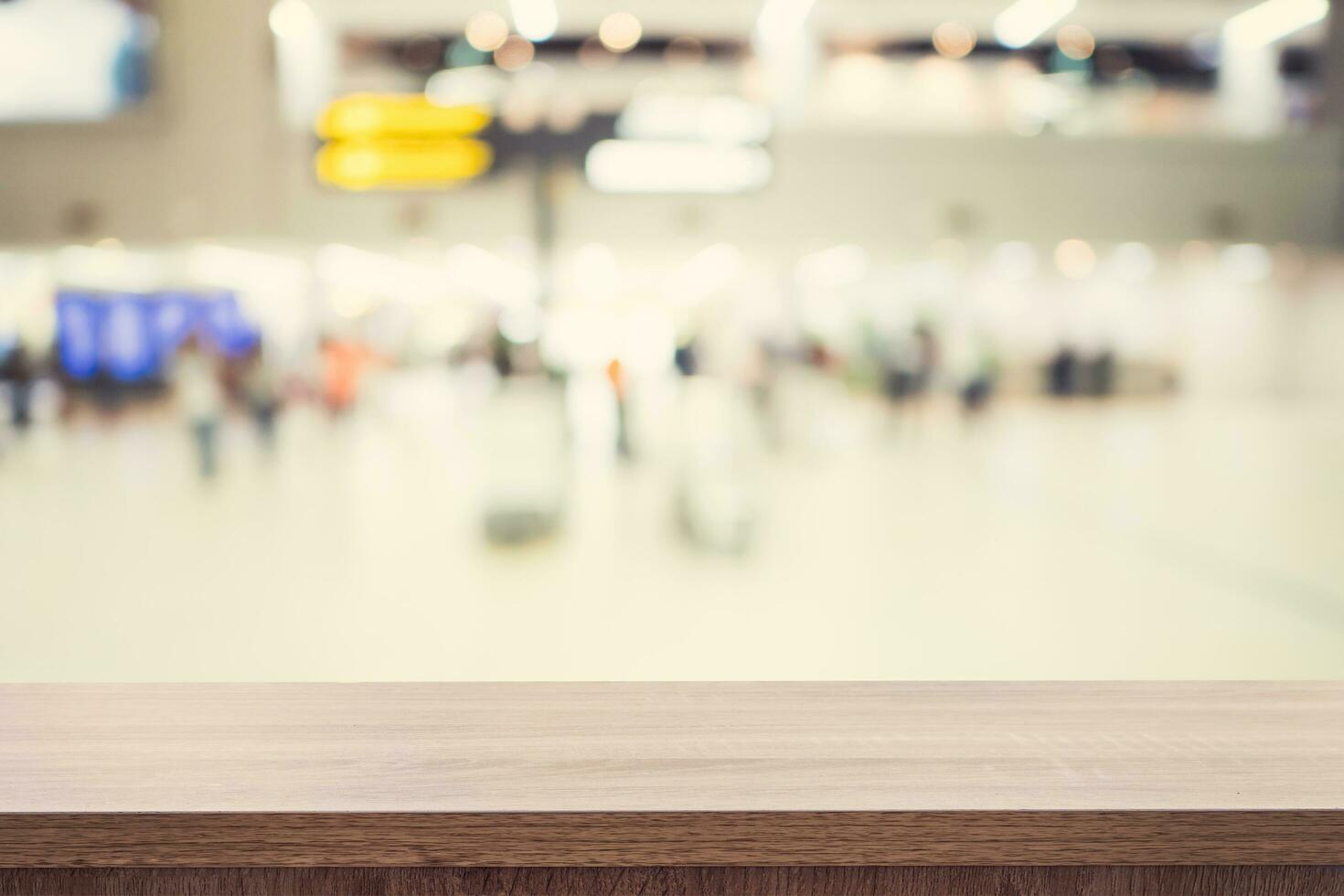 leeg houten tafel voor Product plaatsing of montage en wazig terminal afdeling Bij luchthaven achtergrond. foto