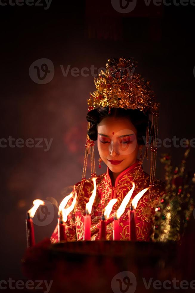 Chinese vrouw maken wensen, bidden, en licht kaarsen. Aan de gelegenheid van de jaar- Chinese nieuw jaar festival, in een vereerd altaar of tempel foto