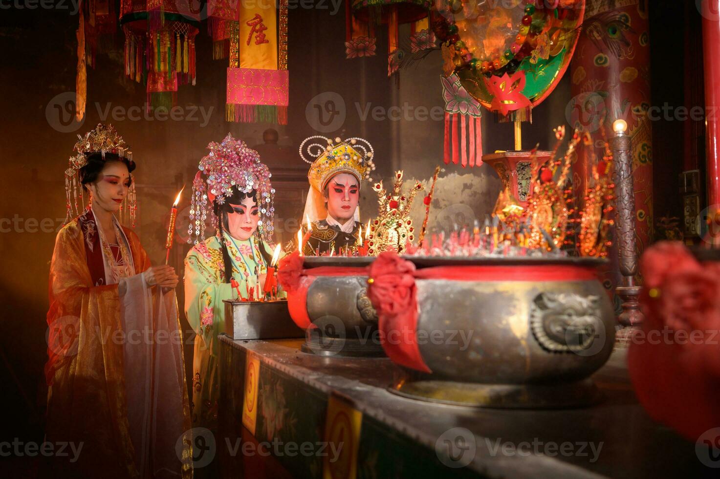 mannetje en vrouw Chinese opera acteurs licht een kaars naar bidden hulde naar de goden naar verbeteren de welvaart voor jezelf Aan de gelegenheid foto