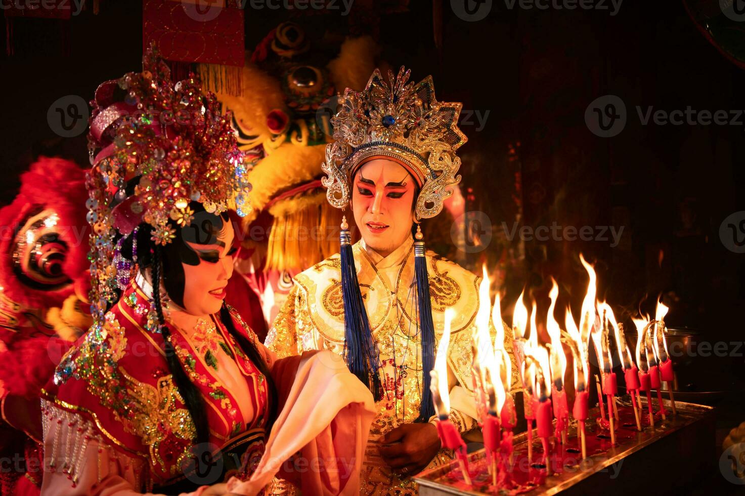 mannetje en vrouw Chinese opera acteurs licht een kaars naar bidden hulde naar de goden naar verbeteren de welvaart voor jezelf Aan de gelegenheid foto