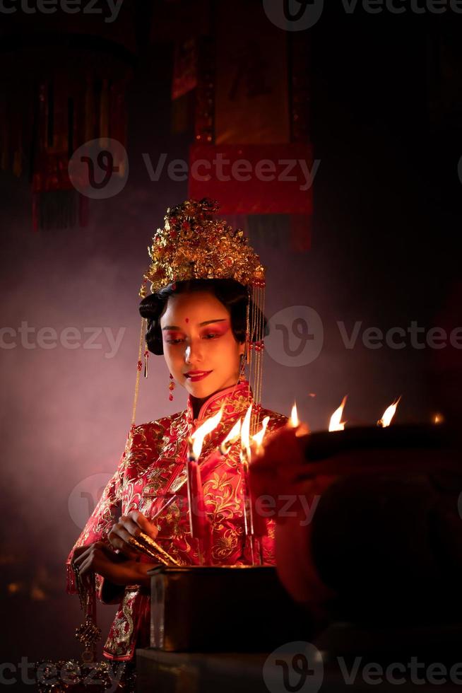 Chinese vrouw maken wensen, bidden, en licht kaarsen. Aan de gelegenheid van de jaar- Chinese nieuw jaar festival, in een vereerd altaar of tempel foto