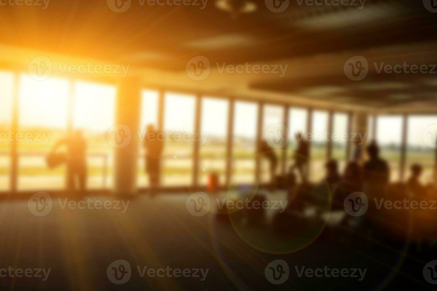 wazig beeld van mensen en toerist aan het wachten voor de lucht vlak in de luchthaven terminal lobby met zon en lens gloed achtergrond. foto