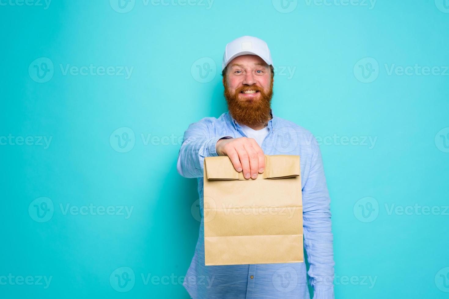 postbode met gelukkig uitdrukking is klaar naar leveren een voedsel pakket foto