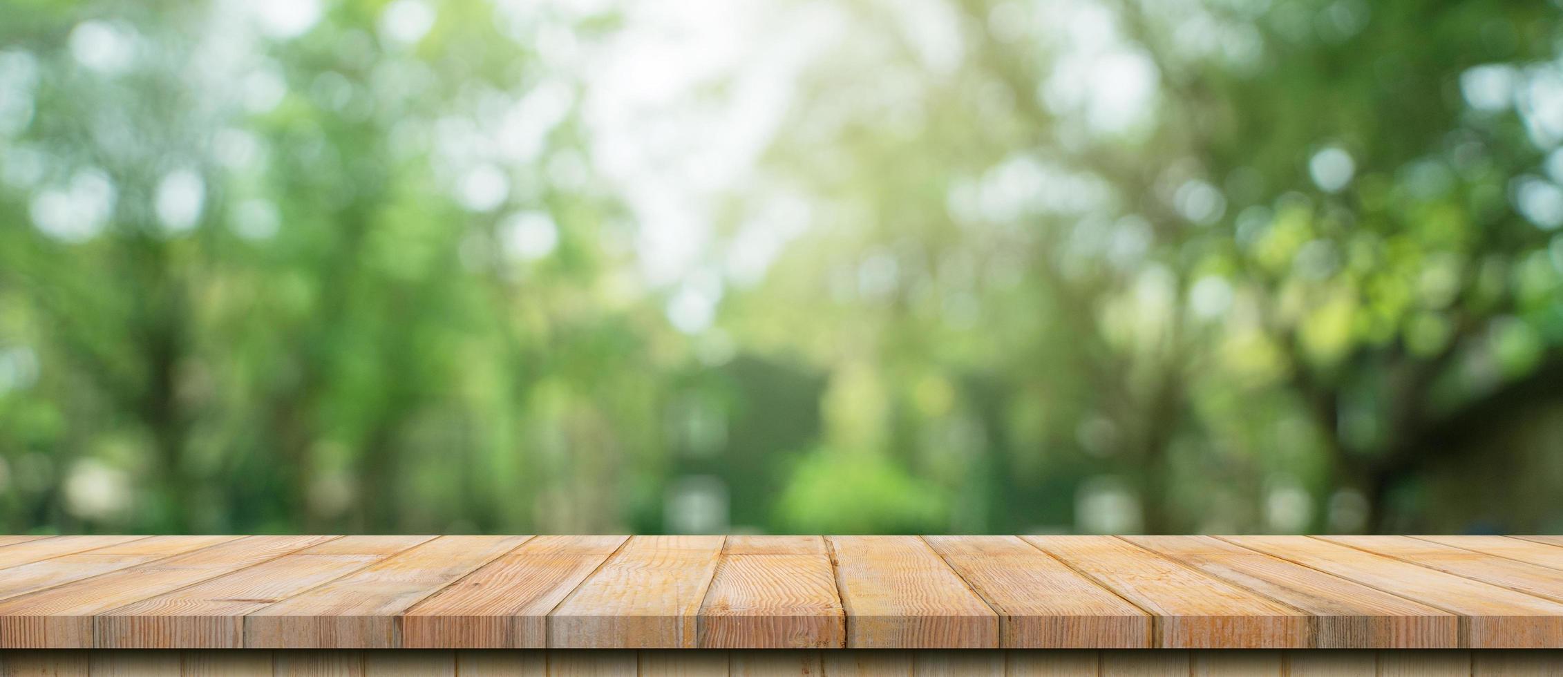 leeg hout tafel en onscherp bokeh en vervagen achtergrond van tuin bomen met zonlicht. Product Scherm sjabloon. foto