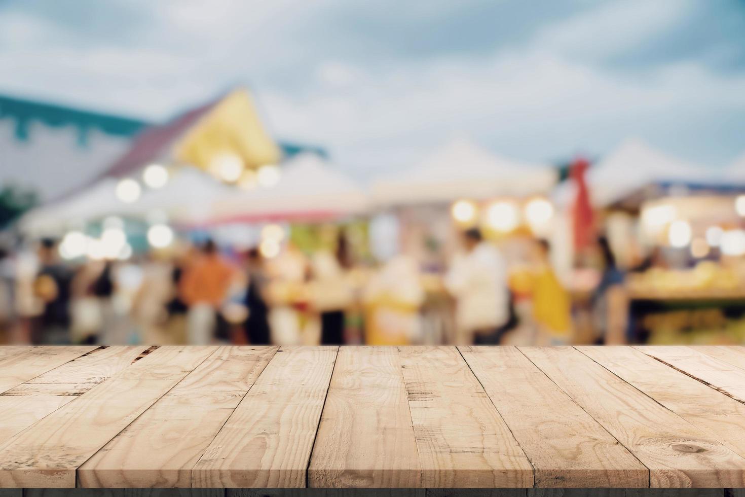 leeg hout tafel en wijnoogst toon wazig onscherp van menigte mensen in wandelen straat festival en boodschappen doen winkelcentrum. foto