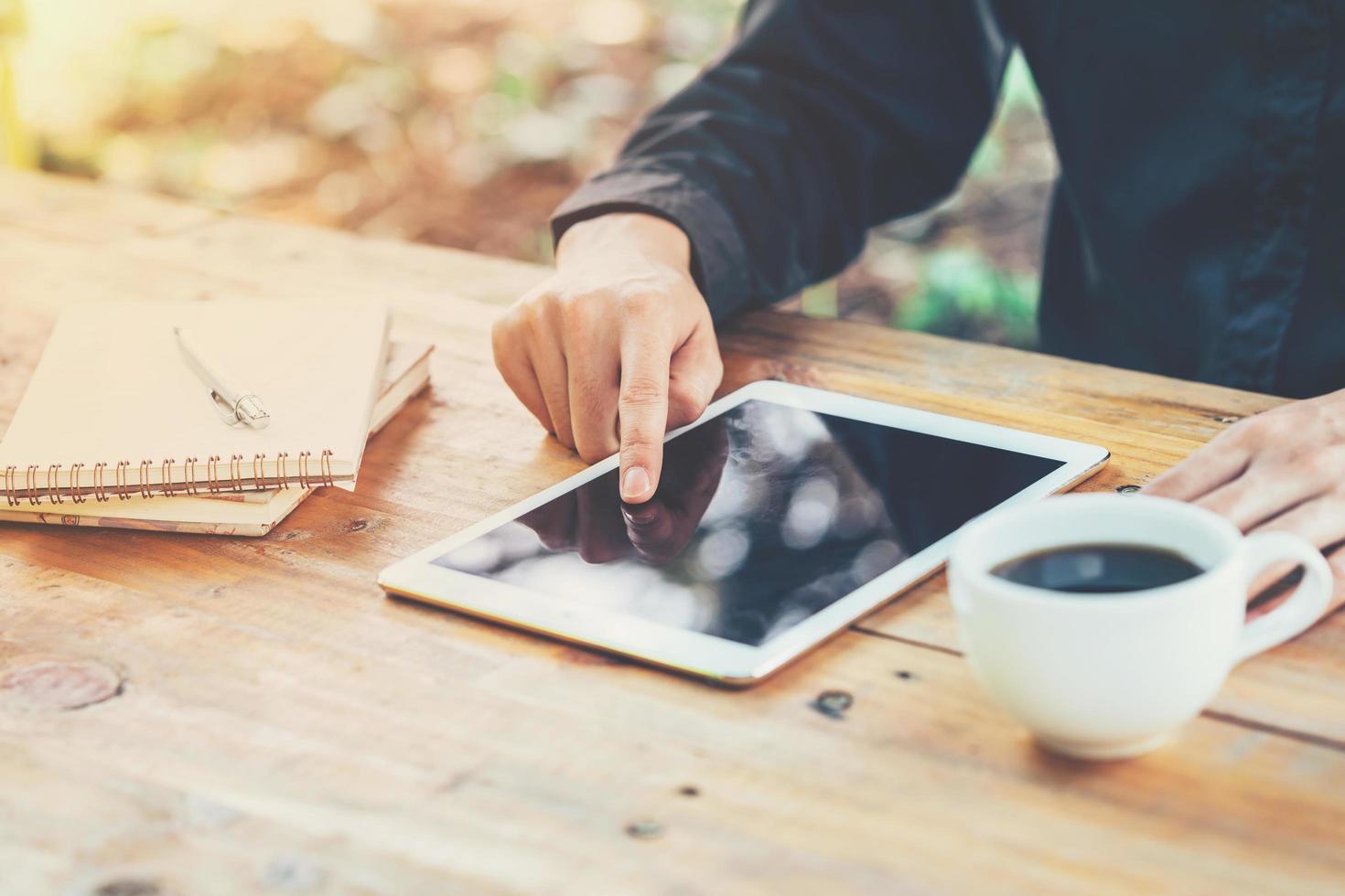 Azië bedrijf Mens gebruik makend van tablet Aan tafel in koffie winkel met wijnoogst afgezwakt filter. foto