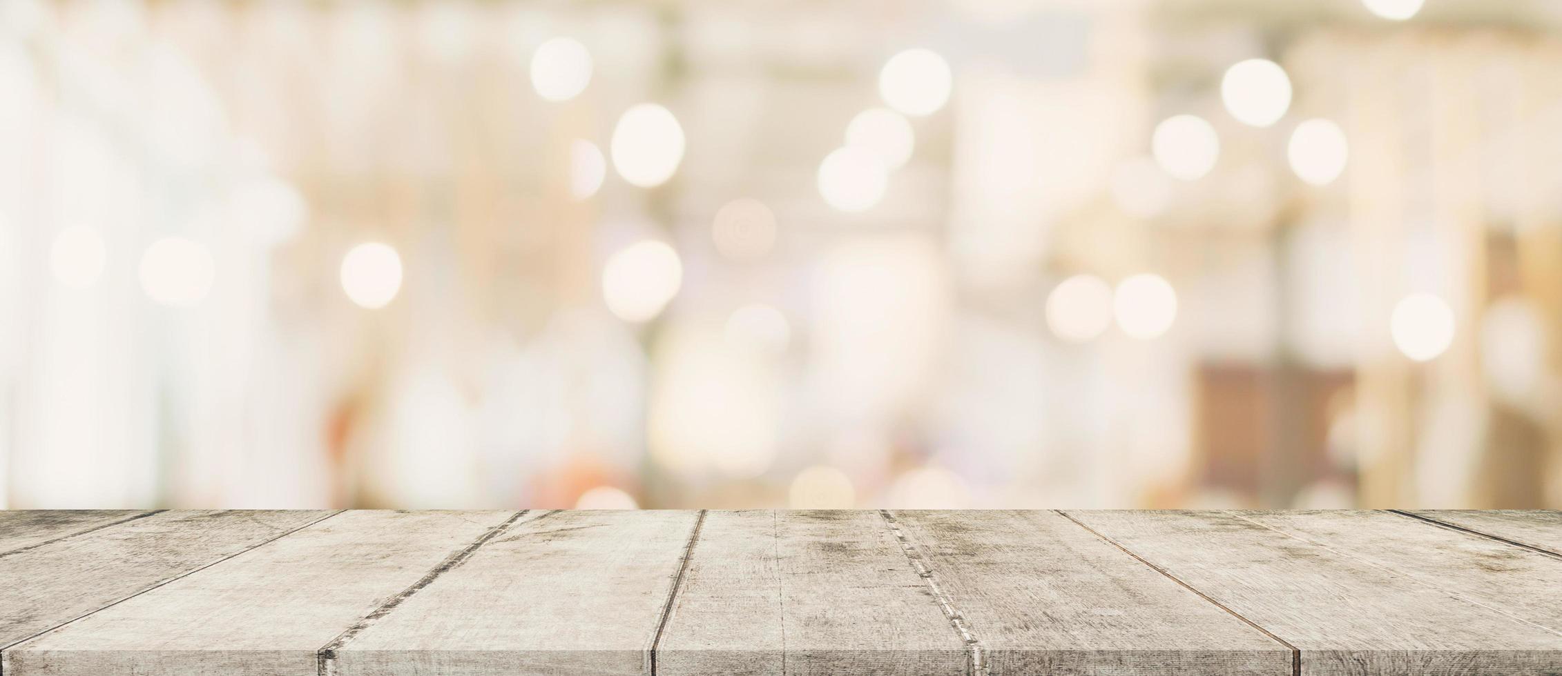 leeg hout tafel en wazig licht tafel in boodschappen doen winkelcentrum met bokeh achtergrond. Product Scherm sjabloon. foto