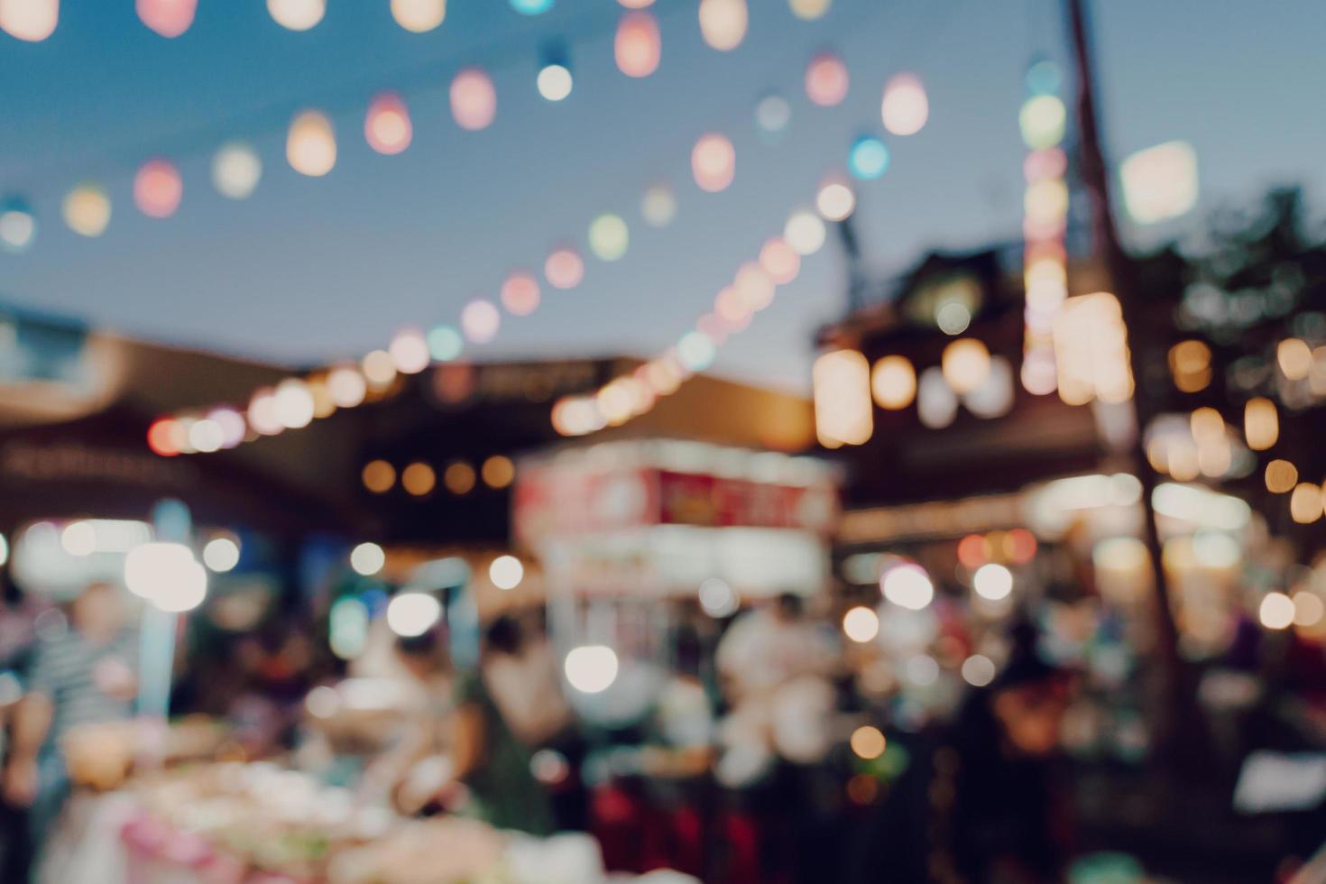 wazig achtergrond Bij nacht markt festival mensen wandelen Aan weg. foto