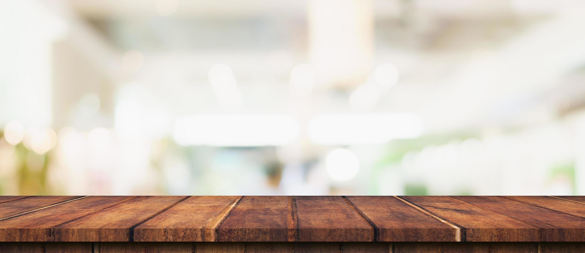 leeg hout tafel en wazig licht tafel in boodschappen doen winkelcentrum met bokeh achtergrond. Product Scherm sjabloon. foto