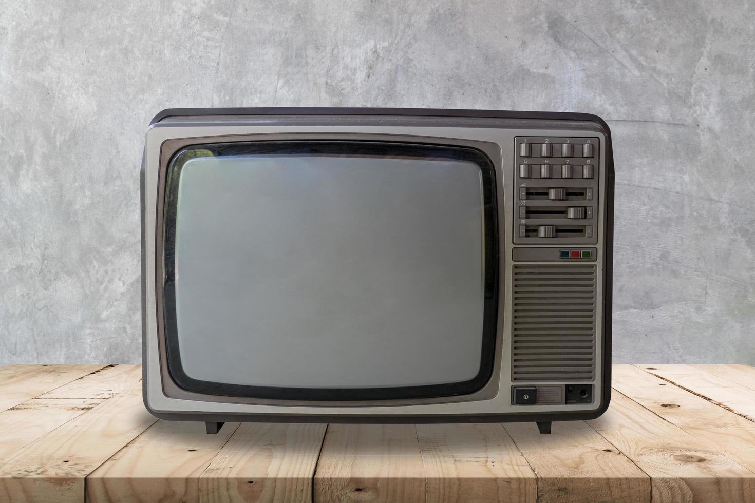 wijnoogst televisie Aan houten tafel en cement muur structuur en achtergrond. foto