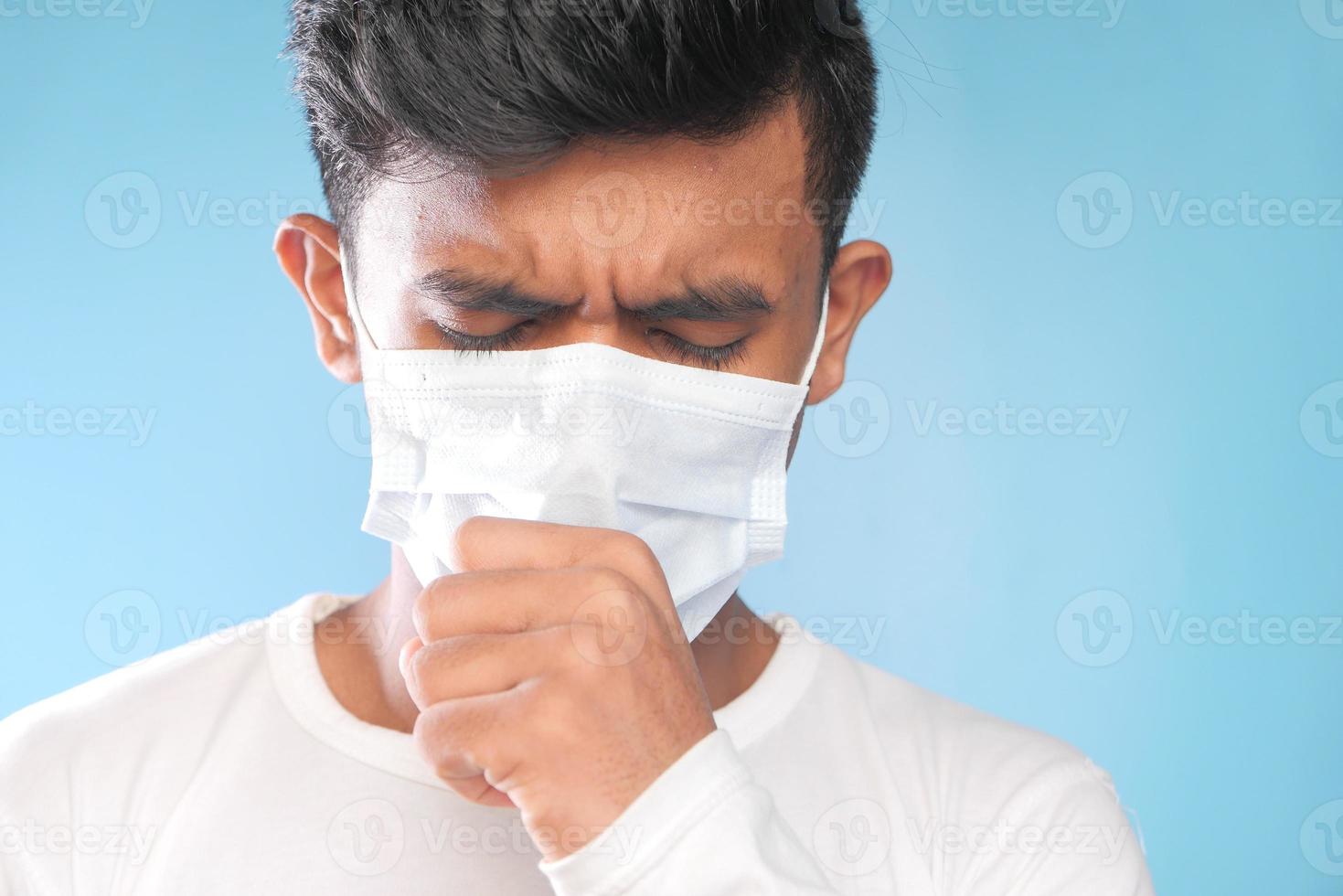 man hoesten met een masker op foto