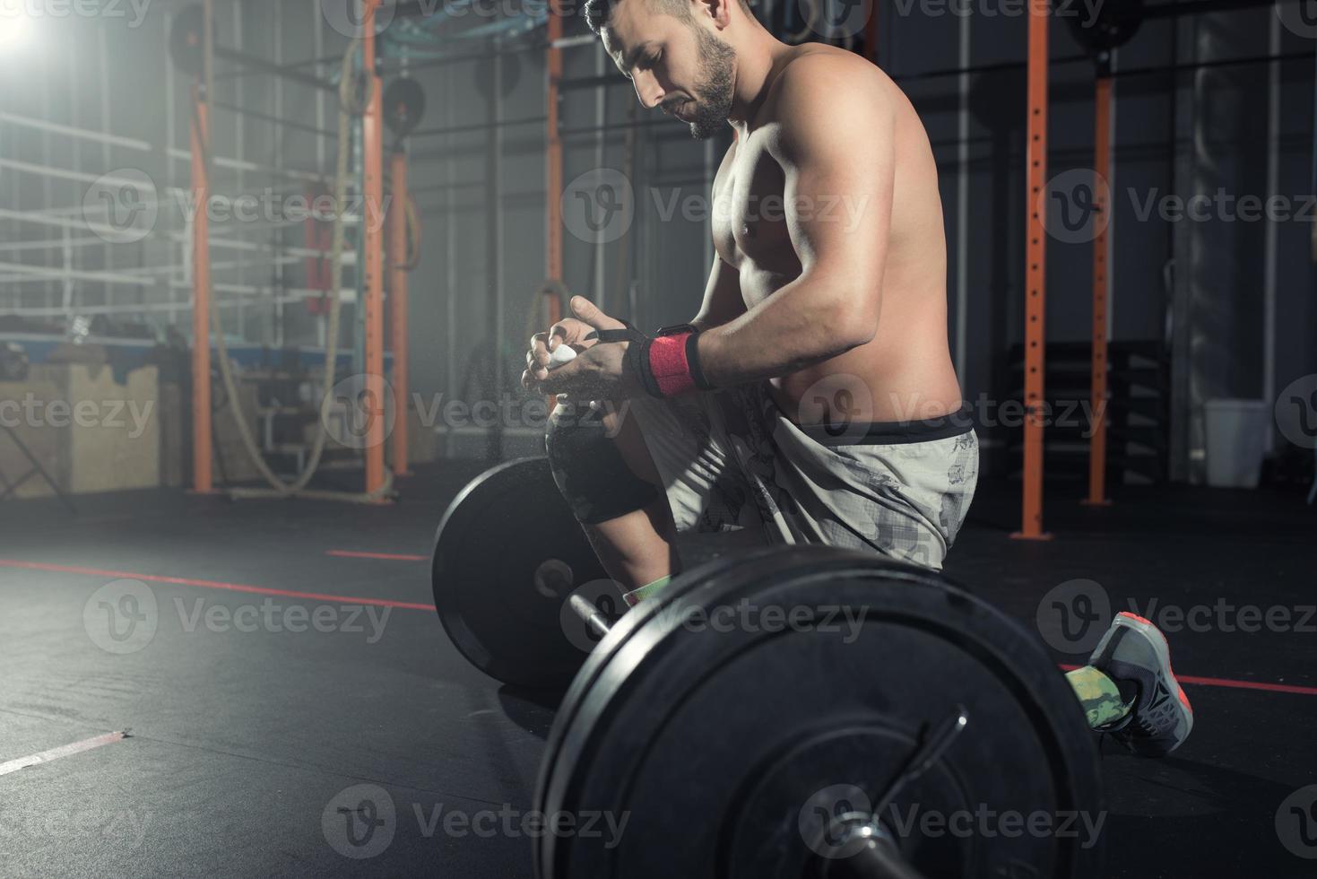 atletisch Mens werken uit Bij de Sportschool met een barbell foto