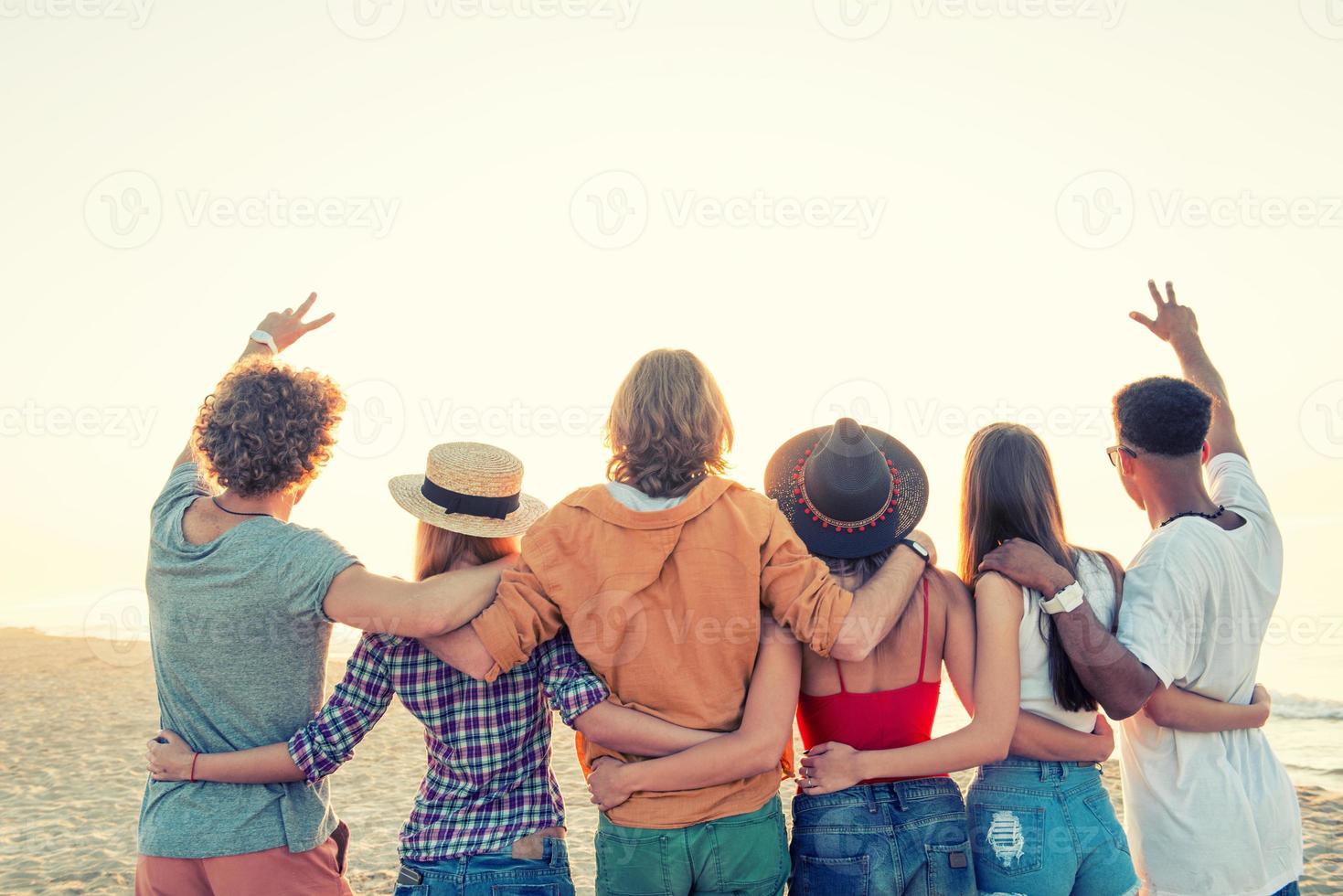 groep van gelukkig vrienden hebben pret Bij oceaan strand foto