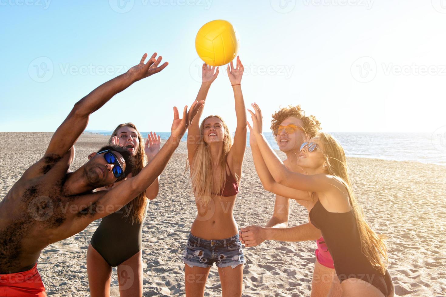 groep van vrienden spelen Bij strand volley Bij de strand foto