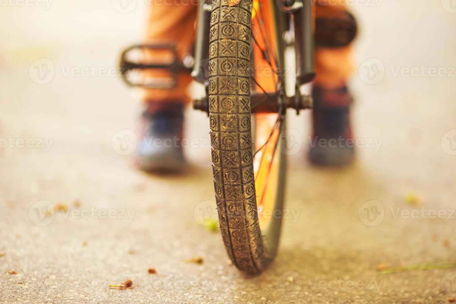 jongen met een fiets Aan de straat. wiel van een kinderen fiets foto