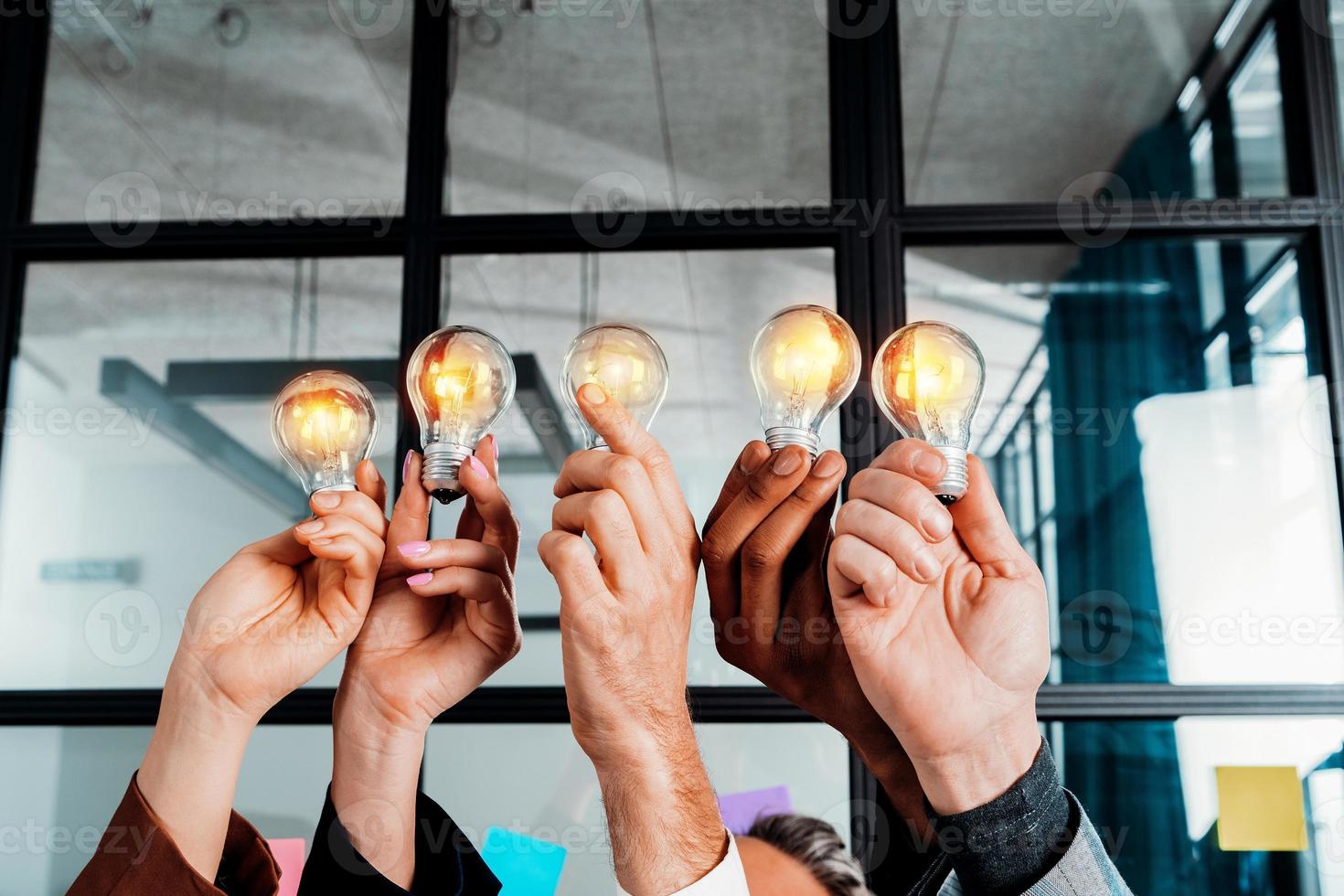 samenspel en brainstorming concept met zakenlieden dat delen een idee met een lamp foto