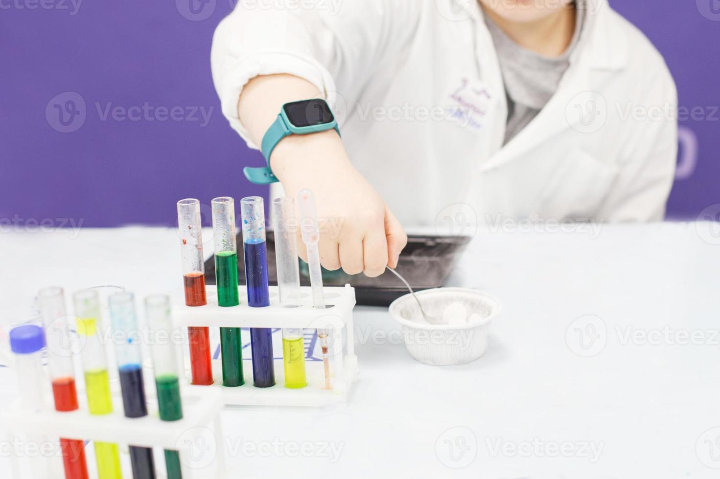 jongen studie wetenschap onderwijs. chemisch laboratorium met test buizen voor experimenten en veelkleurig vloeistoffen foto