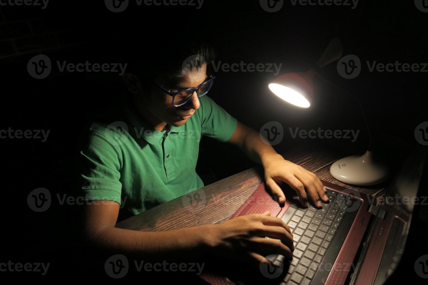 man aan het werk aan een bureau 's nachts foto