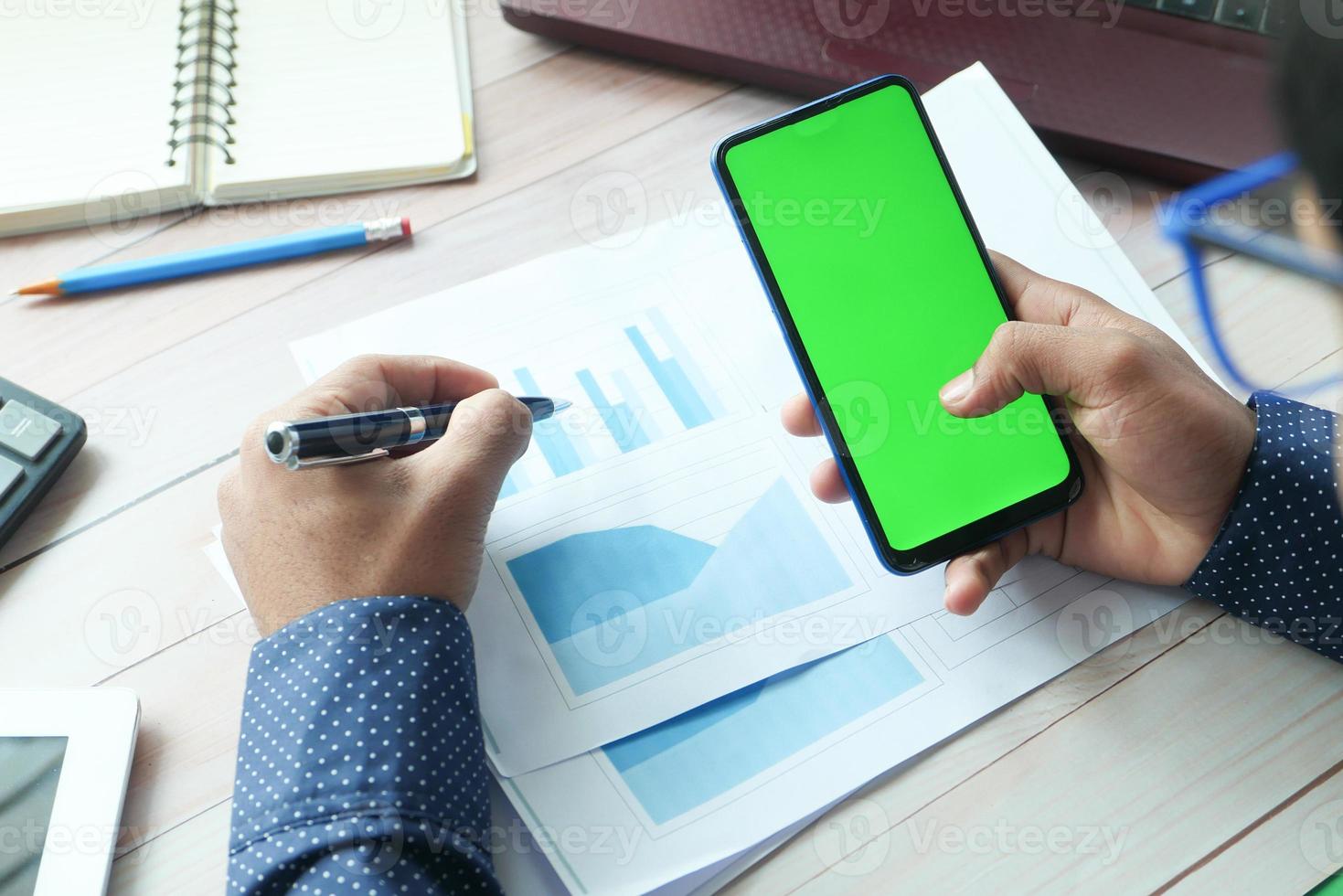 man met behulp van een slimme telefoon op een bureau foto