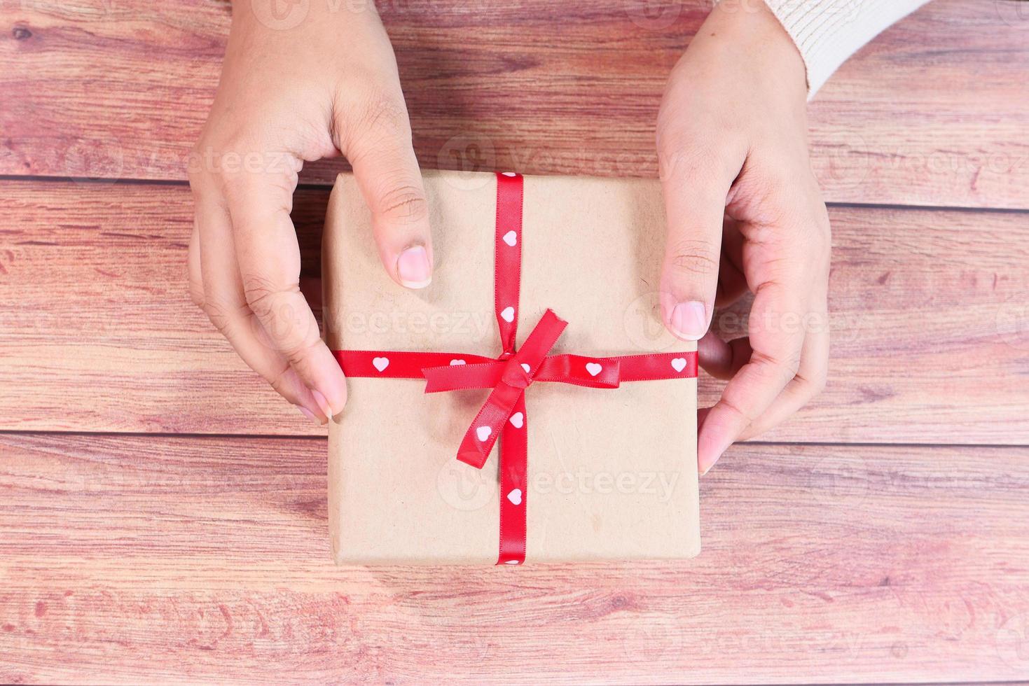 geschenkdoos op houten tafel te houden foto