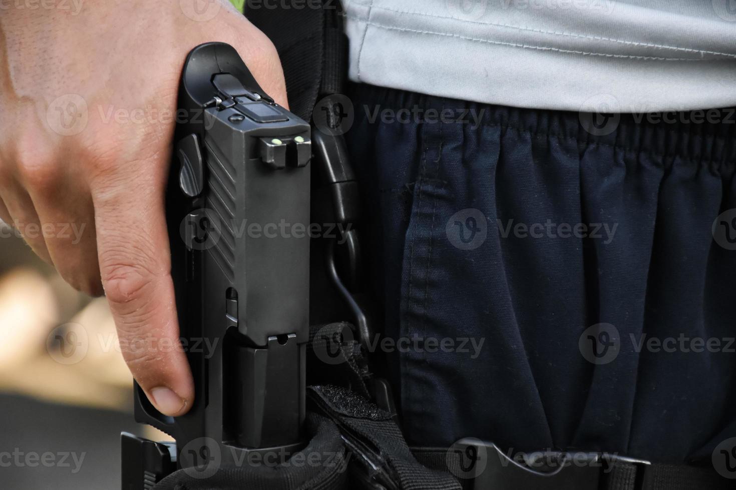 9 mm automatisch pistool in de rechterhand van de schutter, concept voor beveiliging, overval, gangster, lijfwacht over de hele wereld. selectieve focus op pistool. foto