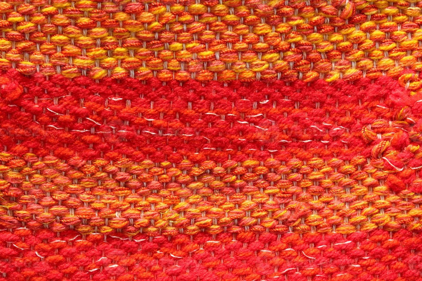 geweven rood en oranje wol kleding stof textuur. hand- gebreid textiel canvas achtergrond. lapwerk tapijt achtergrond. fabriek materiaal draden. abstract ontwerp. detailopname, model, top visie foto