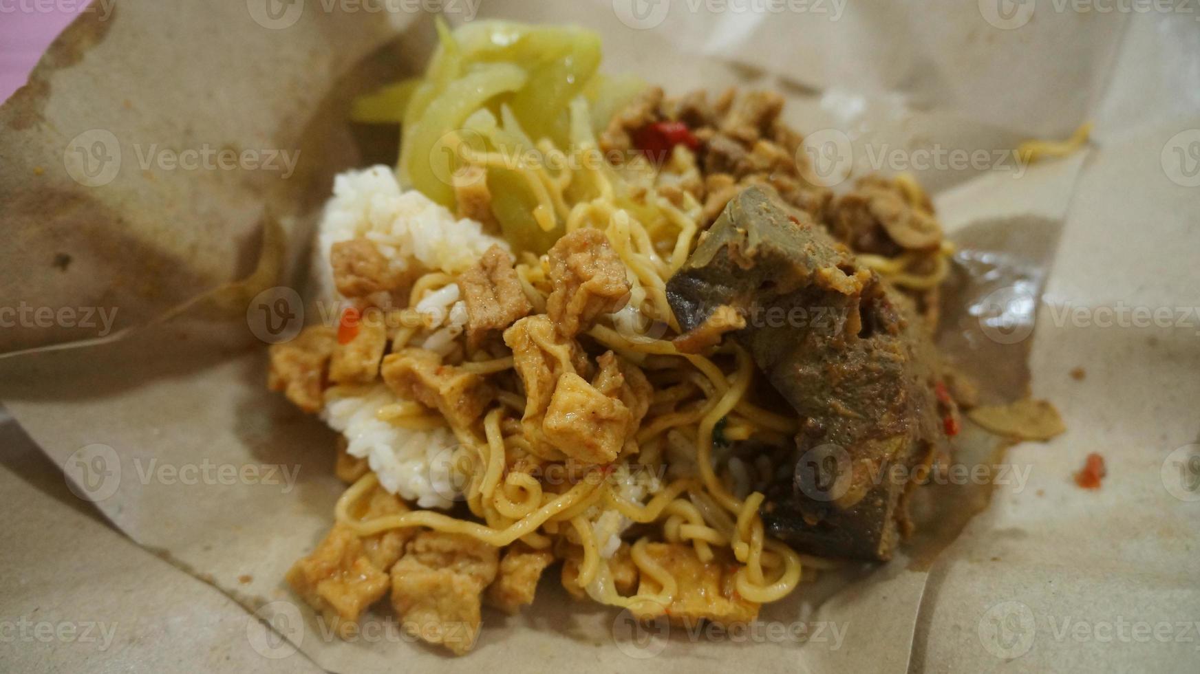 nasi kucing speciaal, kat rijst- speciaal met opor hati sapi Aan een papier inpakken foto