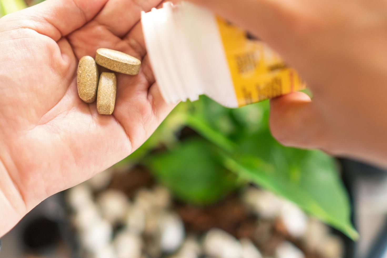 bovenaanzicht van alternatieve biologische geneeskunde tablet aan de kant van de vrouw foto