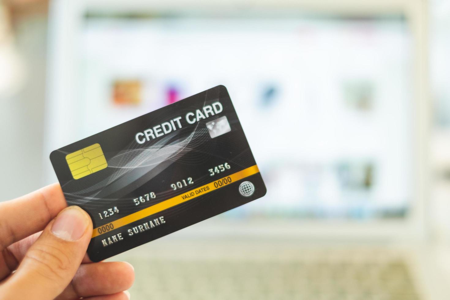 handen met een creditcard en met behulp van een laptop, online winkelconcept foto