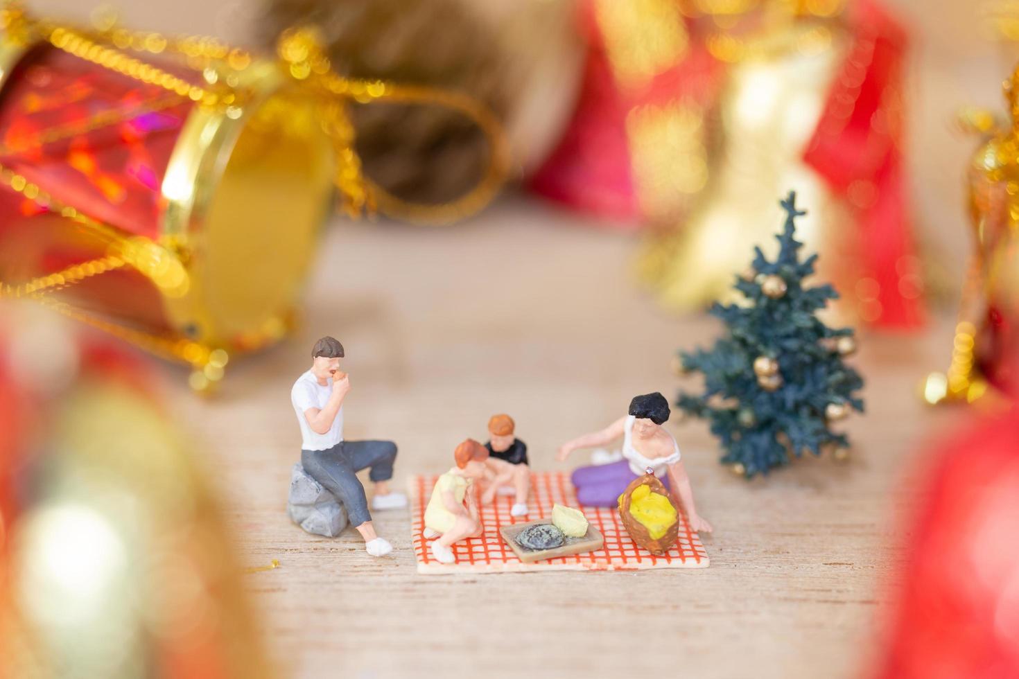 miniatuur gelukkige familie die kerstmis, kerstmis en gelukkig nieuwjaarconcept viert foto