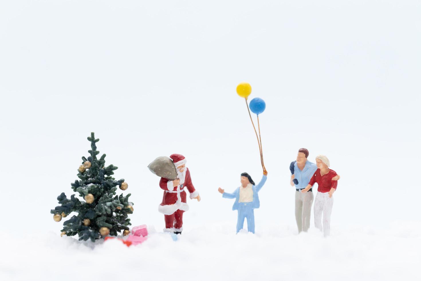 miniatuurmensen met de kerstman met cadeaus voor kinderen, kerstconcept foto